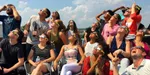 Several people with sunglasses staring into the sun.
