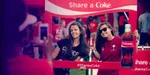 2 girls getting their picture taken while holding up a Share a Coke frame.