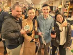 Photo of people at a sampling event holding bottles.