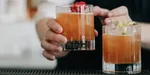 Photo of a bartender serving beautiful bourbon cocktails.
